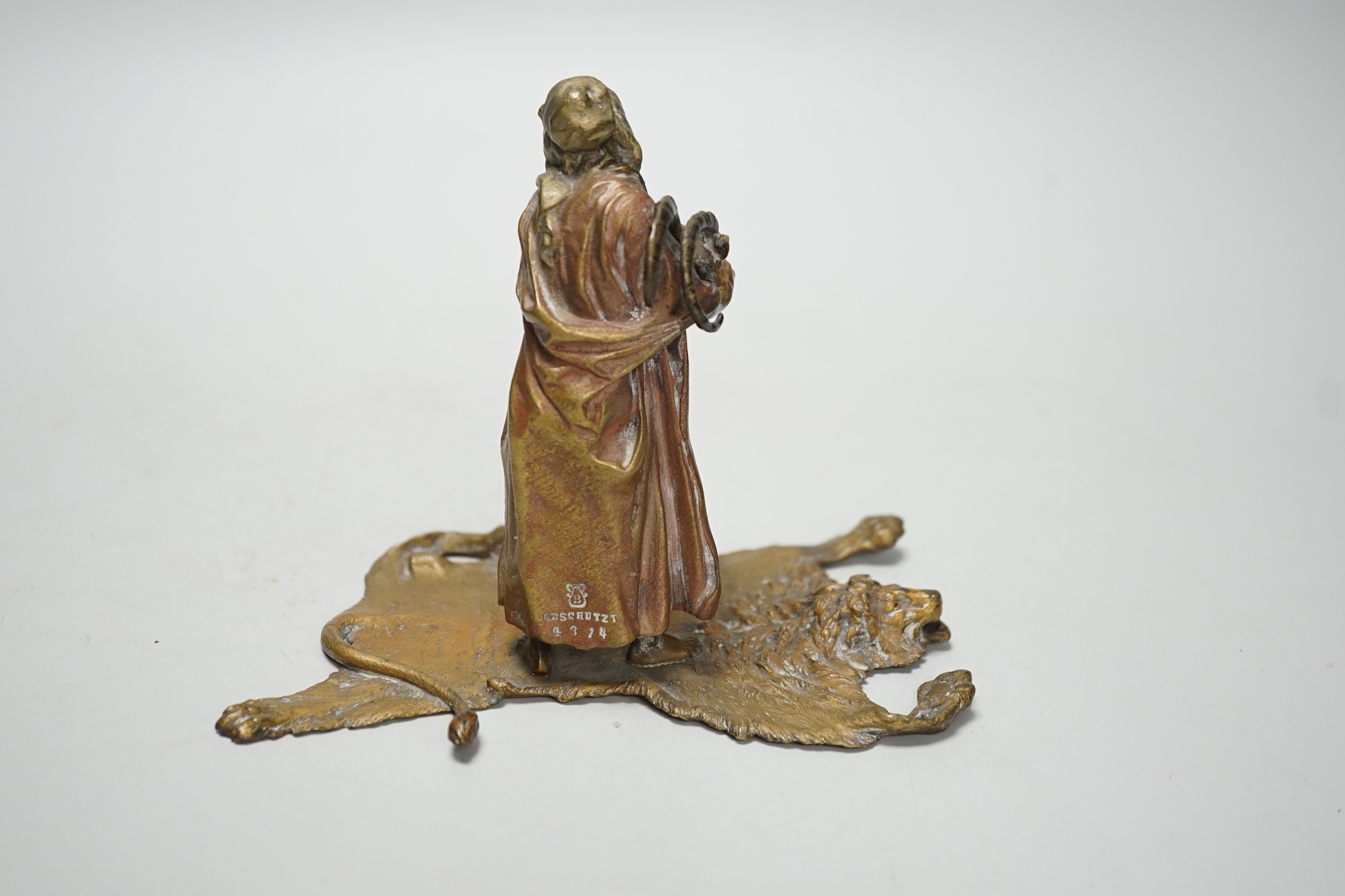 An Austrian cold painted bronze model of a Bedouin trader, depicted holding an Ibex head, standing on a lion skin, after Franz Bergman. 12cm tall